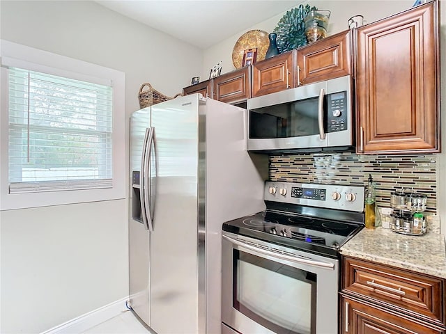 kitchen featuring light stone counters, appliances with stainless steel finishes, and backsplash