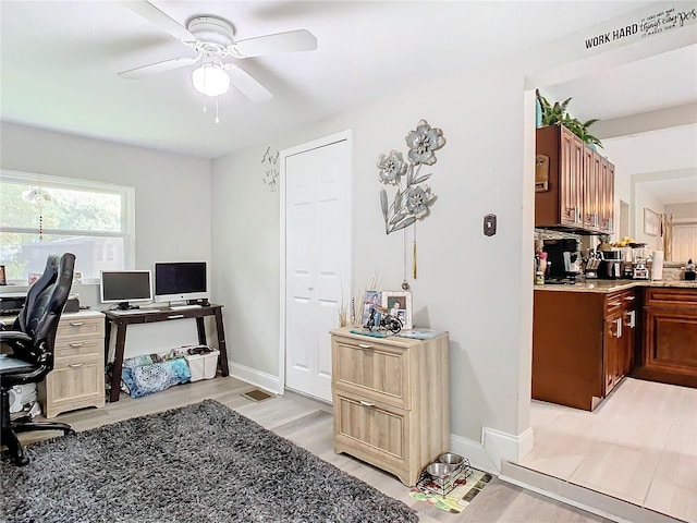 home office featuring light wood-type flooring and ceiling fan