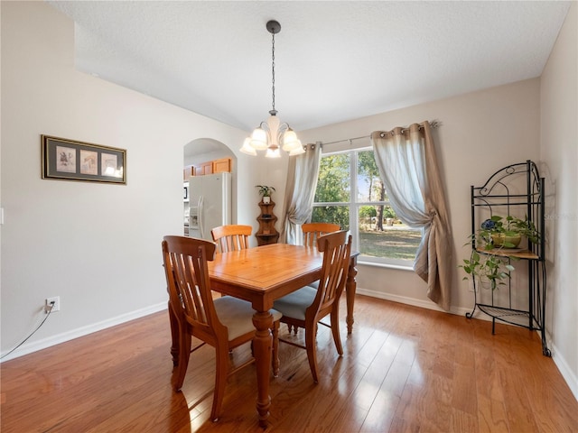 dining room featuring hardwood / wood-style floors and an inviting chandelier