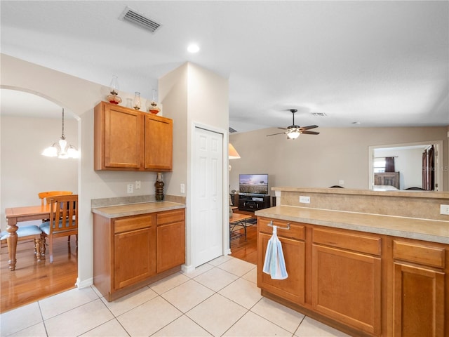 kitchen featuring ceiling fan with notable chandelier, pendant lighting, and light tile patterned floors