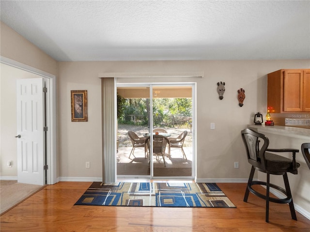 entryway with light hardwood / wood-style flooring and a textured ceiling