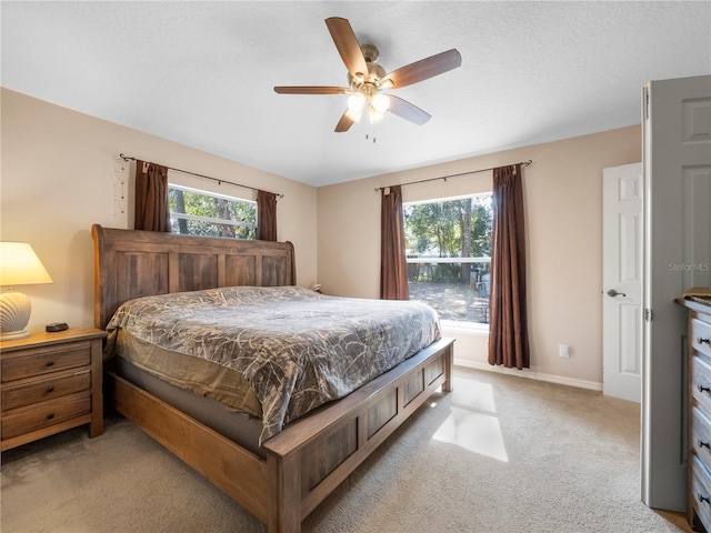 bedroom featuring multiple windows, light carpet, and ceiling fan