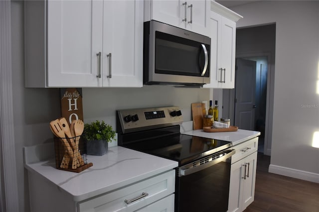 kitchen featuring light stone counters, stainless steel appliances, dark hardwood / wood-style floors, and white cabinets