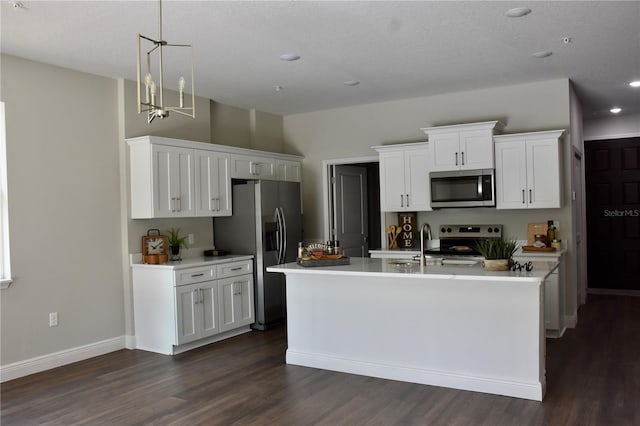 kitchen with dark hardwood / wood-style floors, pendant lighting, white cabinetry, an island with sink, and stainless steel appliances