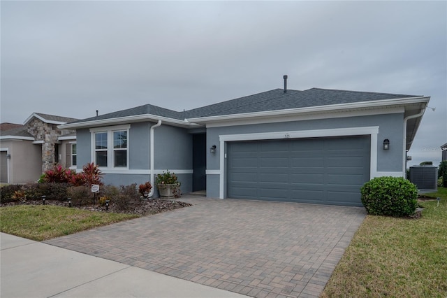 single story home featuring a garage and cooling unit