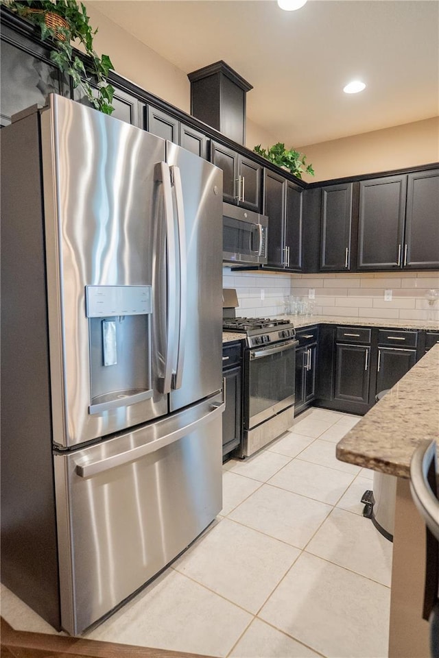 kitchen featuring light tile patterned floors, backsplash, light stone countertops, and appliances with stainless steel finishes