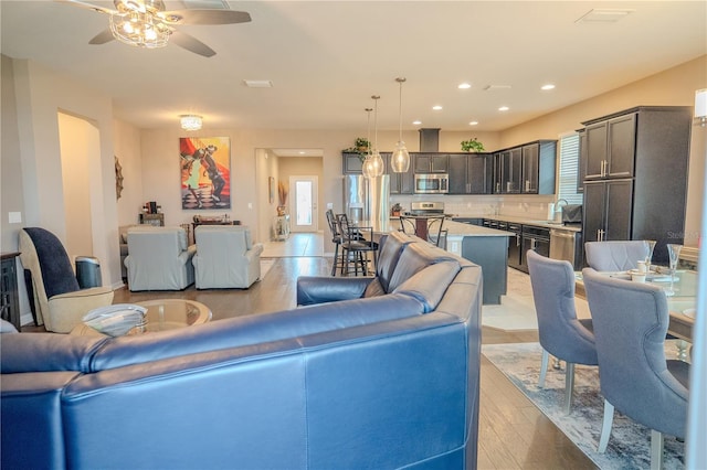 living room featuring light hardwood / wood-style flooring and ceiling fan