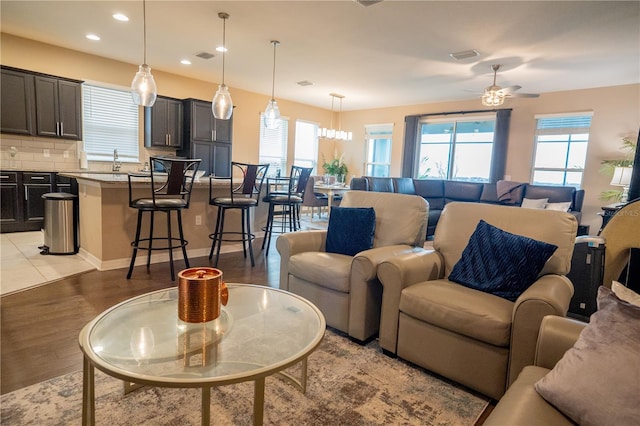 living room featuring sink, ceiling fan, and light hardwood / wood-style flooring