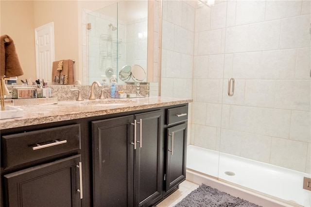 bathroom featuring tile patterned flooring, vanity, and walk in shower