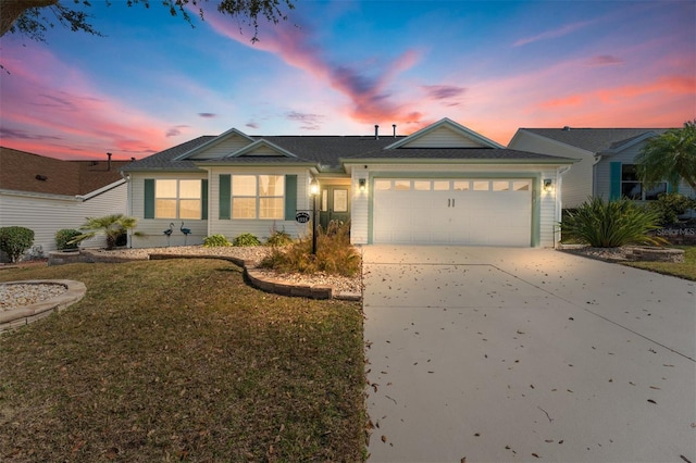 single story home featuring a garage and a lawn