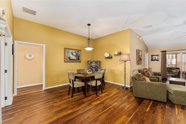 dining room with vaulted ceiling and dark hardwood / wood-style floors