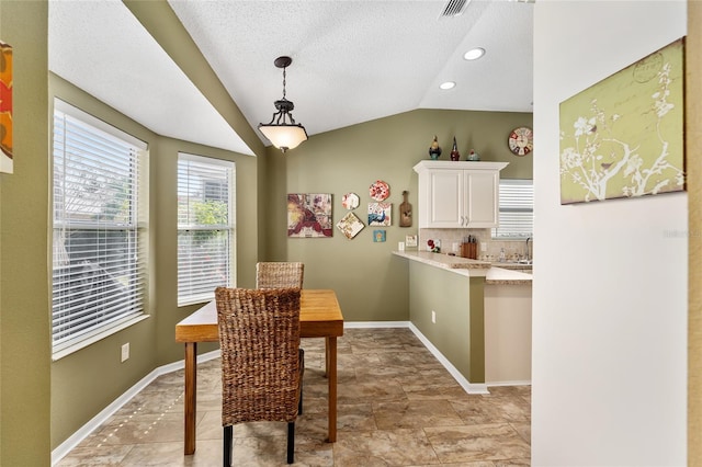 dining space with lofted ceiling and a textured ceiling