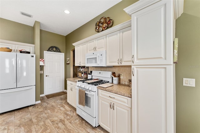 kitchen with light stone counters, white cabinets, white appliances, and decorative backsplash