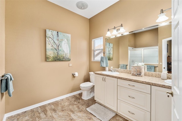 bathroom featuring vanity, toilet, and a shower with door