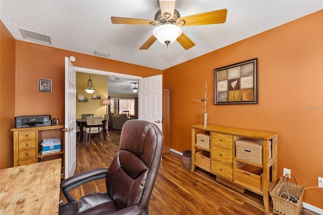 home office with dark wood-type flooring, ceiling fan, and a textured ceiling