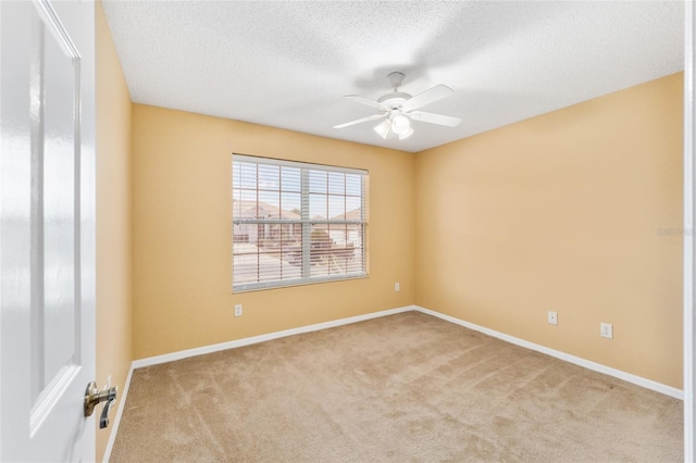 unfurnished room featuring ceiling fan, light colored carpet, and a textured ceiling