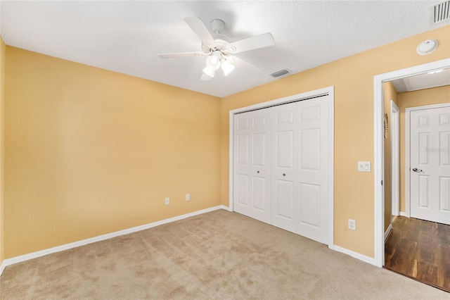 unfurnished bedroom with light carpet, a closet, and ceiling fan