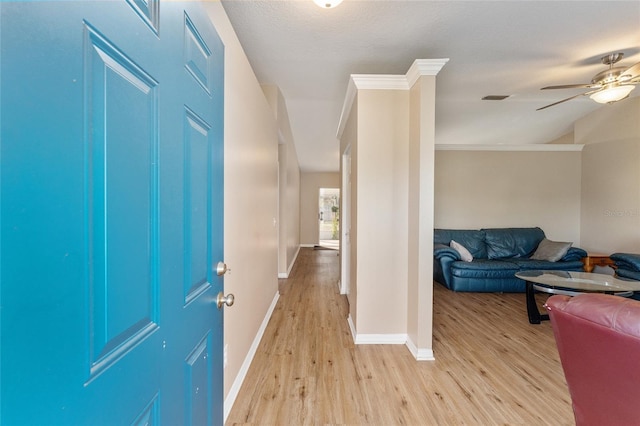 entrance foyer featuring ceiling fan, ornamental molding, a textured ceiling, and light wood-type flooring