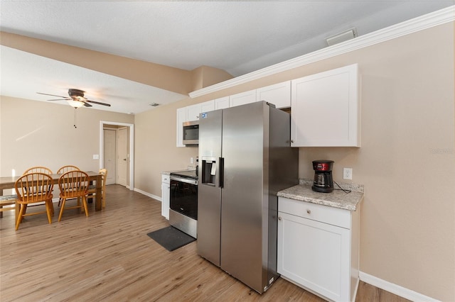 kitchen with stainless steel appliances, white cabinetry, ceiling fan, and light hardwood / wood-style floors