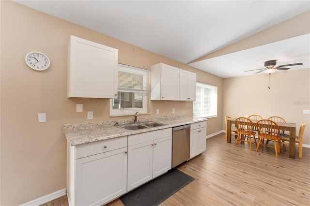 kitchen with sink, white cabinetry, vaulted ceiling, light hardwood / wood-style flooring, and dishwasher