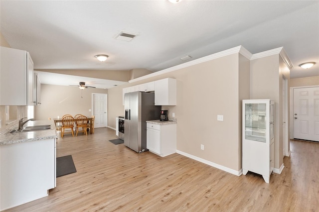 kitchen with stainless steel refrigerator with ice dispenser, sink, white cabinetry, vaulted ceiling, and light hardwood / wood-style floors