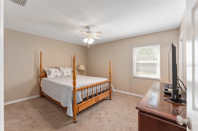 carpeted bedroom featuring ceiling fan and a textured ceiling