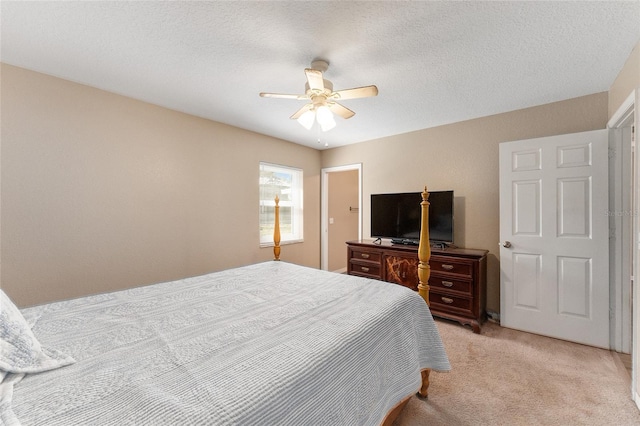 bedroom with ceiling fan, light carpet, and a textured ceiling