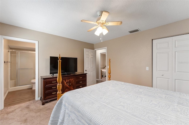 bedroom with ceiling fan, light carpet, a closet, and a textured ceiling