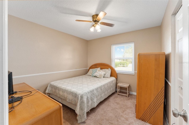 carpeted bedroom with ceiling fan and a textured ceiling