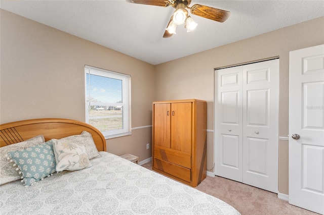 carpeted bedroom featuring ceiling fan and a closet