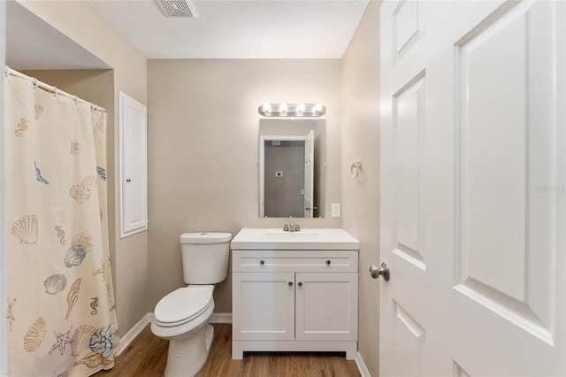 bathroom with hardwood / wood-style flooring, vanity, and toilet