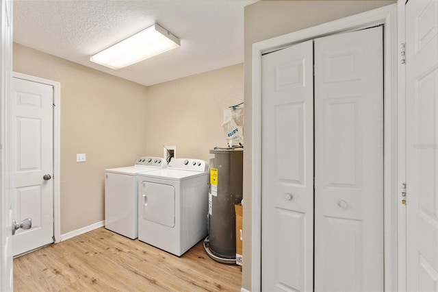 clothes washing area with separate washer and dryer, electric water heater, and light wood-type flooring