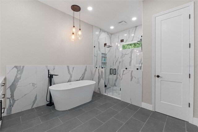 bathroom with tile patterned flooring, shower with separate bathtub, and tile walls