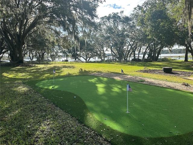 surrounding community with a water view and a lawn