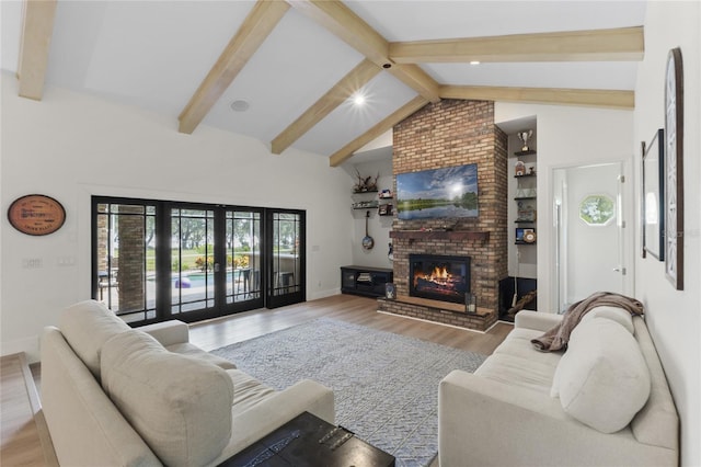 living room with french doors, high vaulted ceiling, light hardwood / wood-style flooring, beamed ceiling, and a fireplace