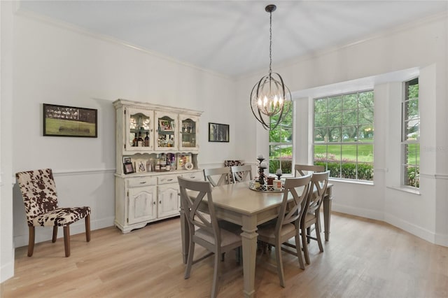 dining space with crown molding, light hardwood / wood-style floors, and a chandelier