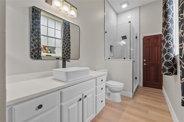 bathroom with vanity, toilet, an enclosed shower, and hardwood / wood-style floors