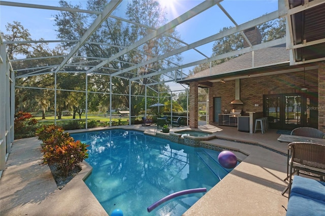 view of pool with an in ground hot tub, ceiling fan, glass enclosure, and a patio area