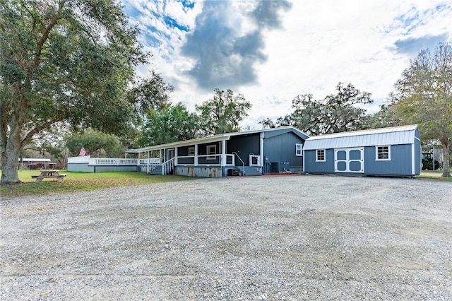 manufactured / mobile home featuring an outbuilding and covered porch