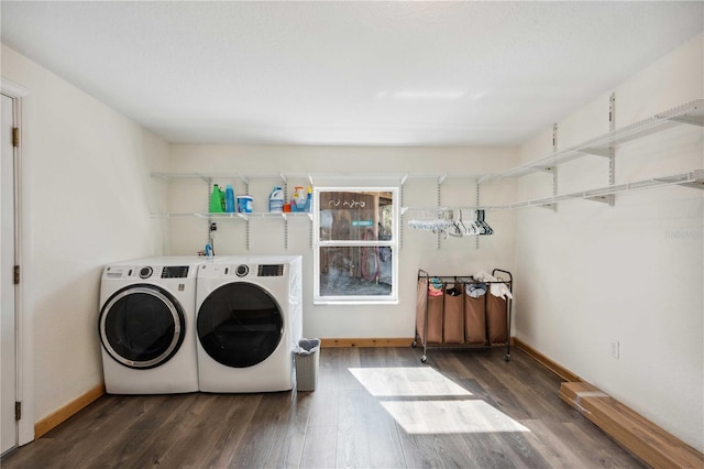 clothes washing area with washing machine and dryer and dark hardwood / wood-style flooring