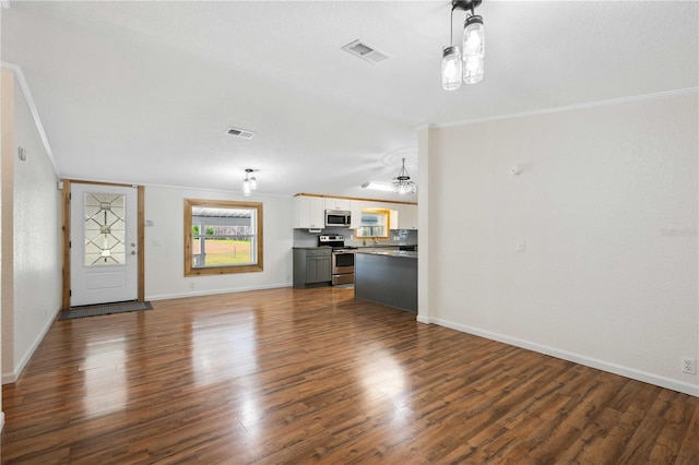 unfurnished living room featuring dark wood-type flooring and ornamental molding