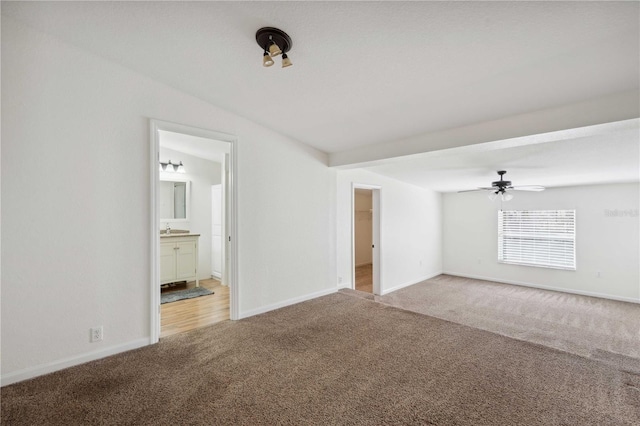 empty room with carpet flooring, sink, and ceiling fan