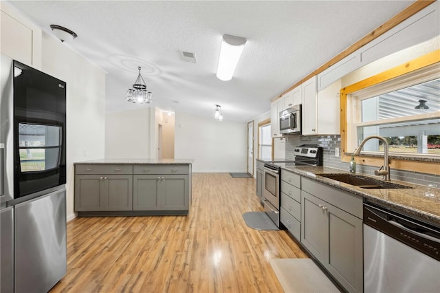 kitchen with pendant lighting, sink, gray cabinets, appliances with stainless steel finishes, and white cabinets