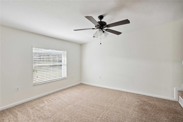 carpeted empty room with ceiling fan and a textured ceiling