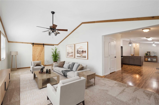 carpeted living area with a barn door, baseboards, a ceiling fan, lofted ceiling, and wood finished floors