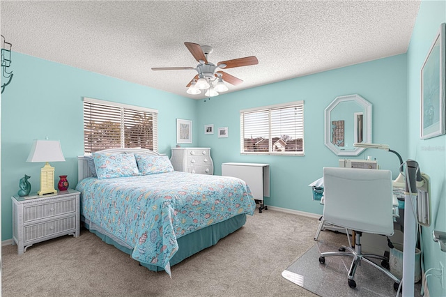 carpeted bedroom featuring ceiling fan and a textured ceiling