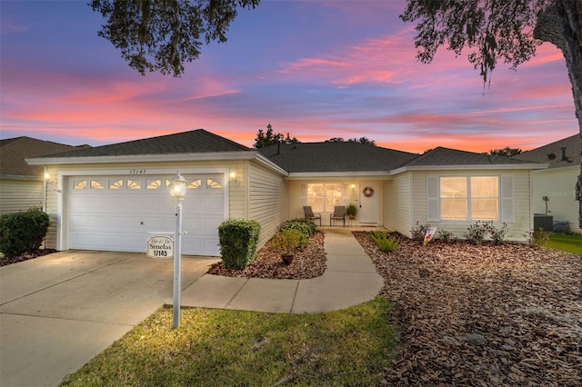 single story home featuring cooling unit and a garage