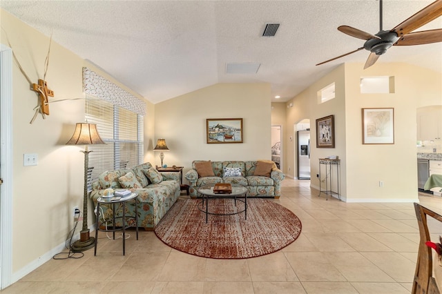 tiled living room featuring ceiling fan, lofted ceiling, and a textured ceiling