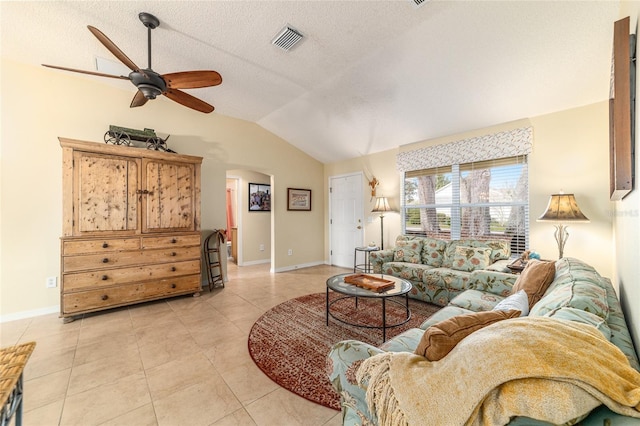 living room with vaulted ceiling, light tile patterned flooring, ceiling fan, and a textured ceiling