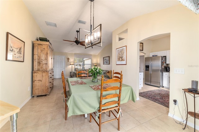 dining room with ceiling fan with notable chandelier, lofted ceiling, and light tile patterned floors